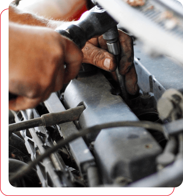 A person is working on something in the engine compartment of an automobile.